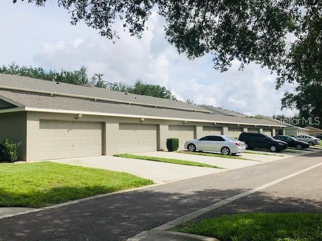 A row of residential townhomes with attached garages and parked cars in front — 12740 LANGSTAFF DRIVE, WINDERMERE, FL