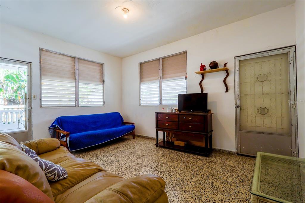 A living room features a blue sofa, a brown leather couch, and a wooden media console — 2244 REPARTO MATIAS, RINCON, PR
