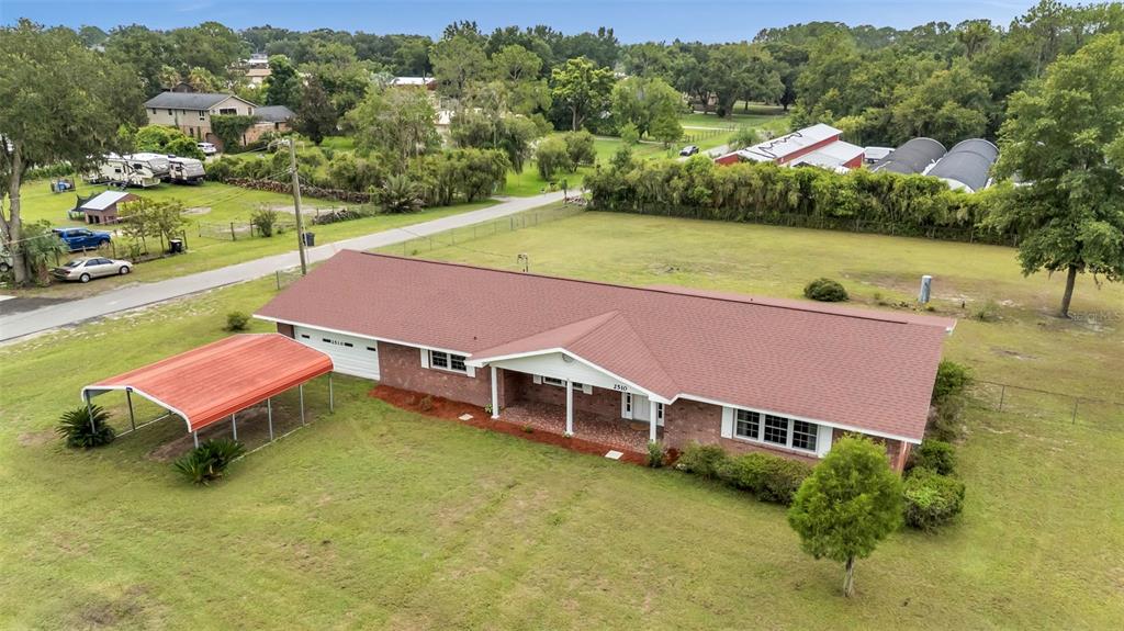 An aerial view shows a single-story brick house with a red roof and attached carport — 2510 GIBSONIA GALLOWAY ROAD, LAKELAND, FL