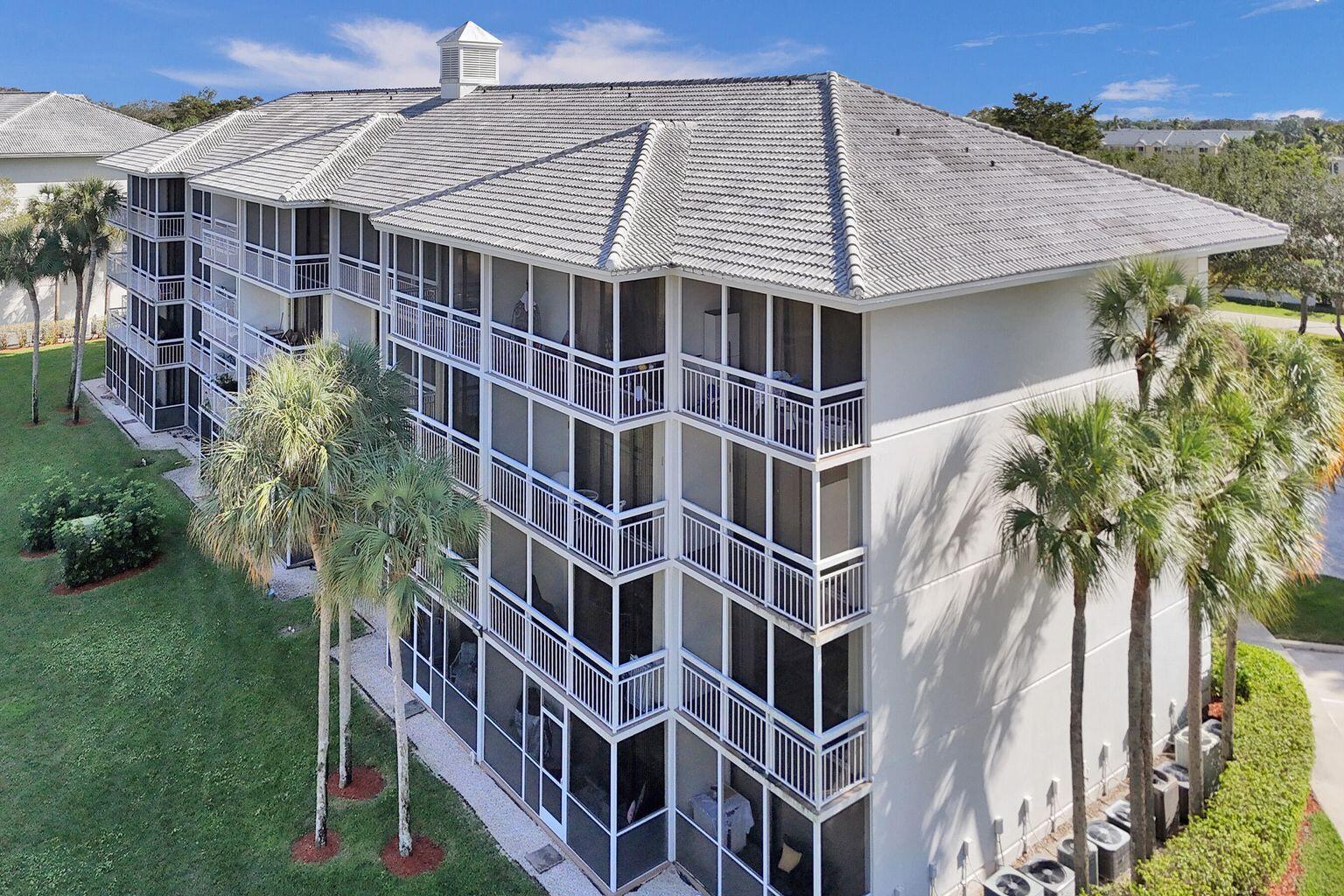 An aerial view of a multi-story apartment building with screened balconies and a tiled roof — 6193 Balboa Circle # 201, Boca Raton FL 33433, BOCA RATON, FL