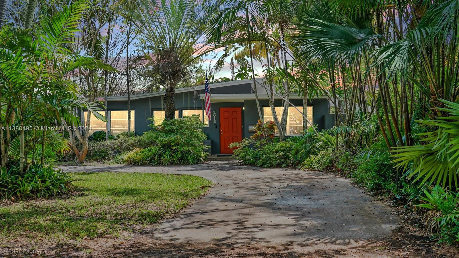 A single-story house with a bright red door and a curved driveway surrounded by palms — 2018 Fletcher St, Hollywood FL 33020, HOLLYWOOD, FL