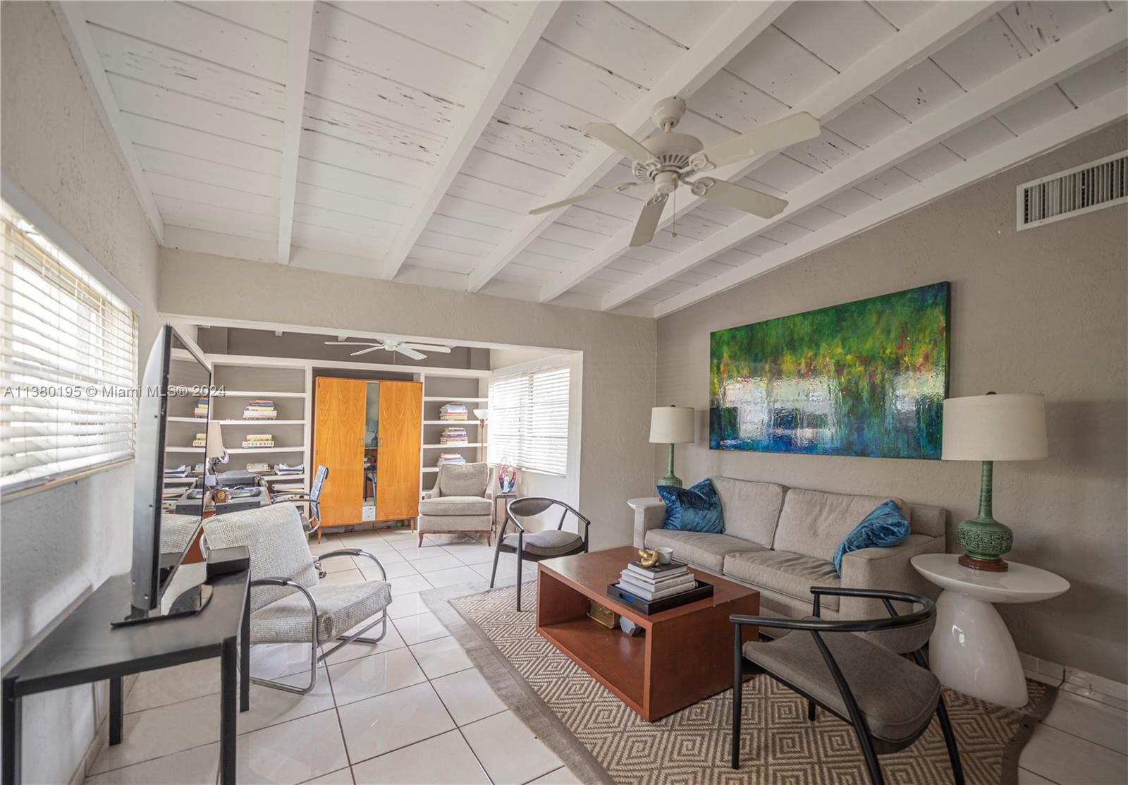 A living room features white tile floors, a beamed ceiling, and a large abstract painting — 2018 Fletcher St, Hollywood FL 33020, HOLLYWOOD, FL
