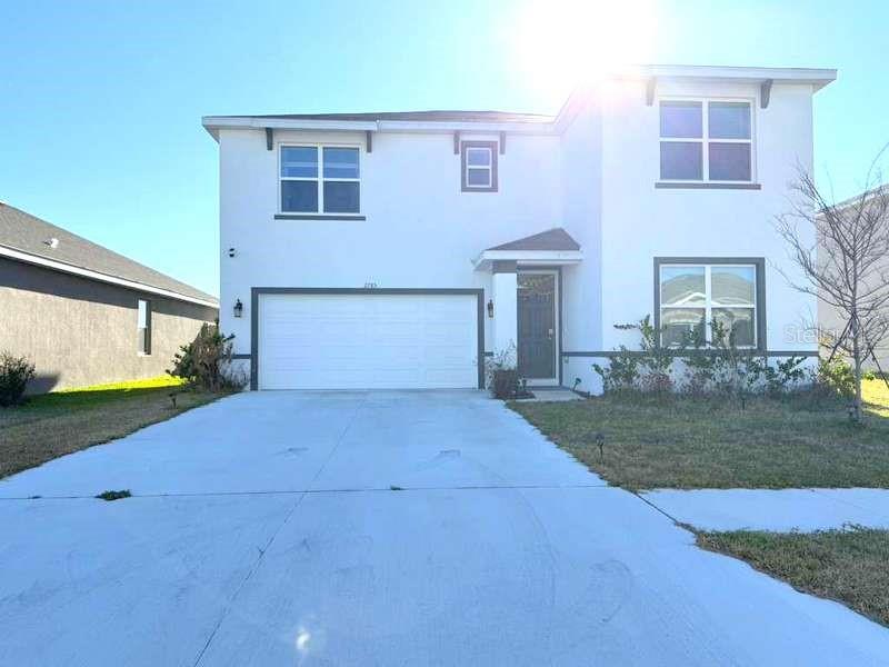 A two-story white house with a two-car garage and a front entrance — 2785 GARDINER LANE, ZEPHYRHILLS, FL