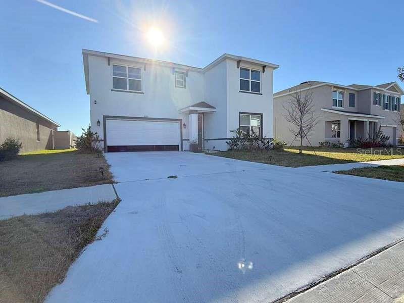 A two-story white house with a two-car garage and a concrete driveway — 2785 GARDINER LANE, ZEPHYRHILLS, FL