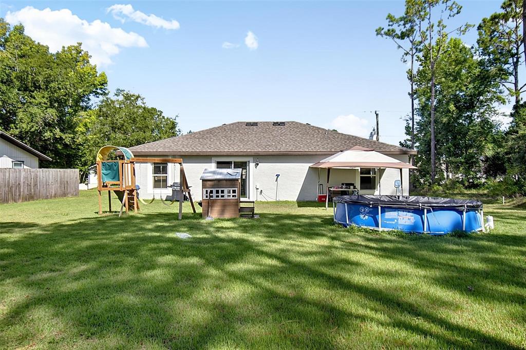 The backyard features a lawn, a playset, a small playhouse, a gazebo, and an above-ground pool — 70 PEBBLE BEACH DRIVE, PALM COAST, FL