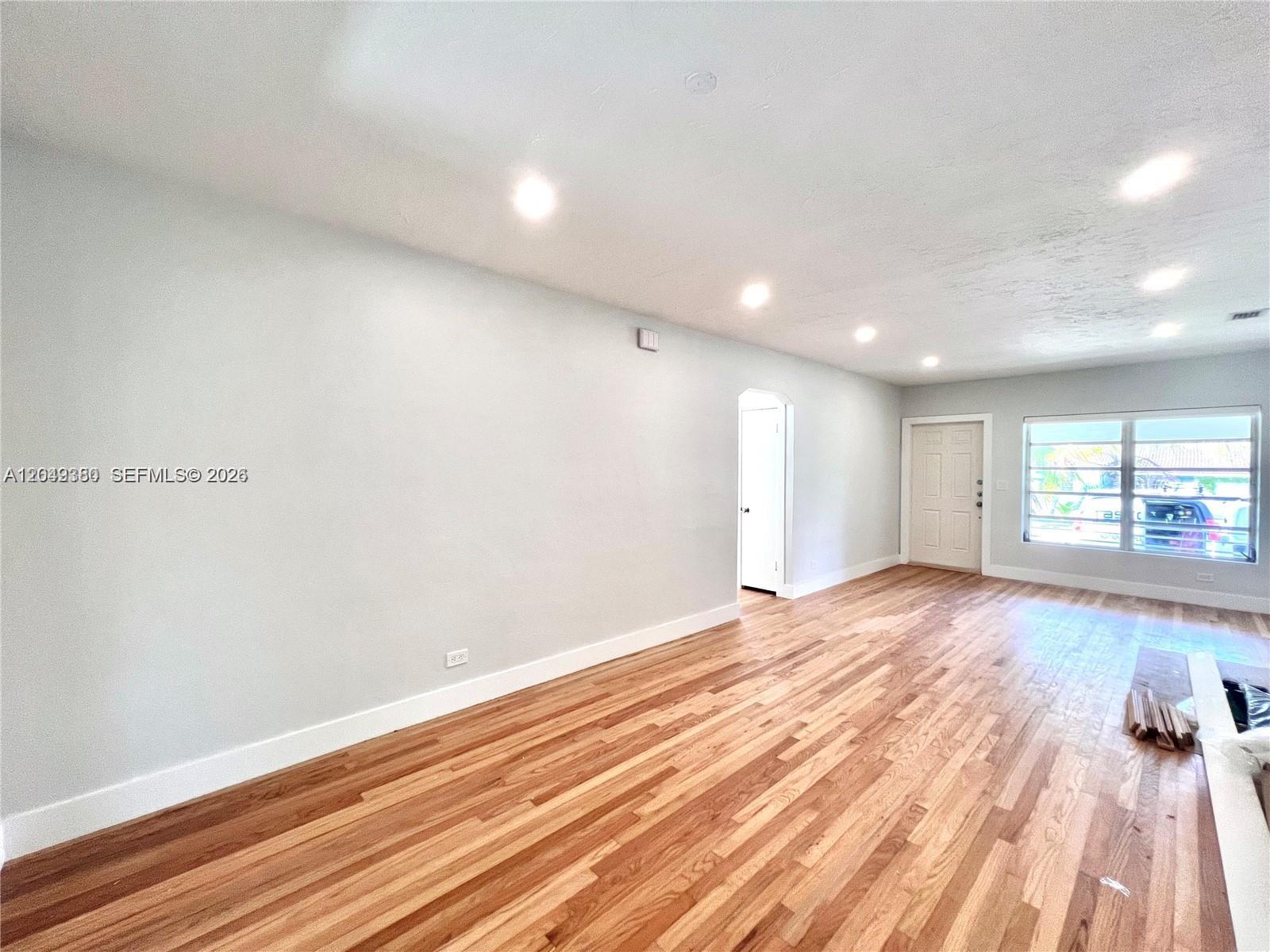 An empty room features light-colored walls, recessed lighting, and hardwood flooring — 2245 SW 25th Ter # 0, Miami FL 33133, MIAMI, FL