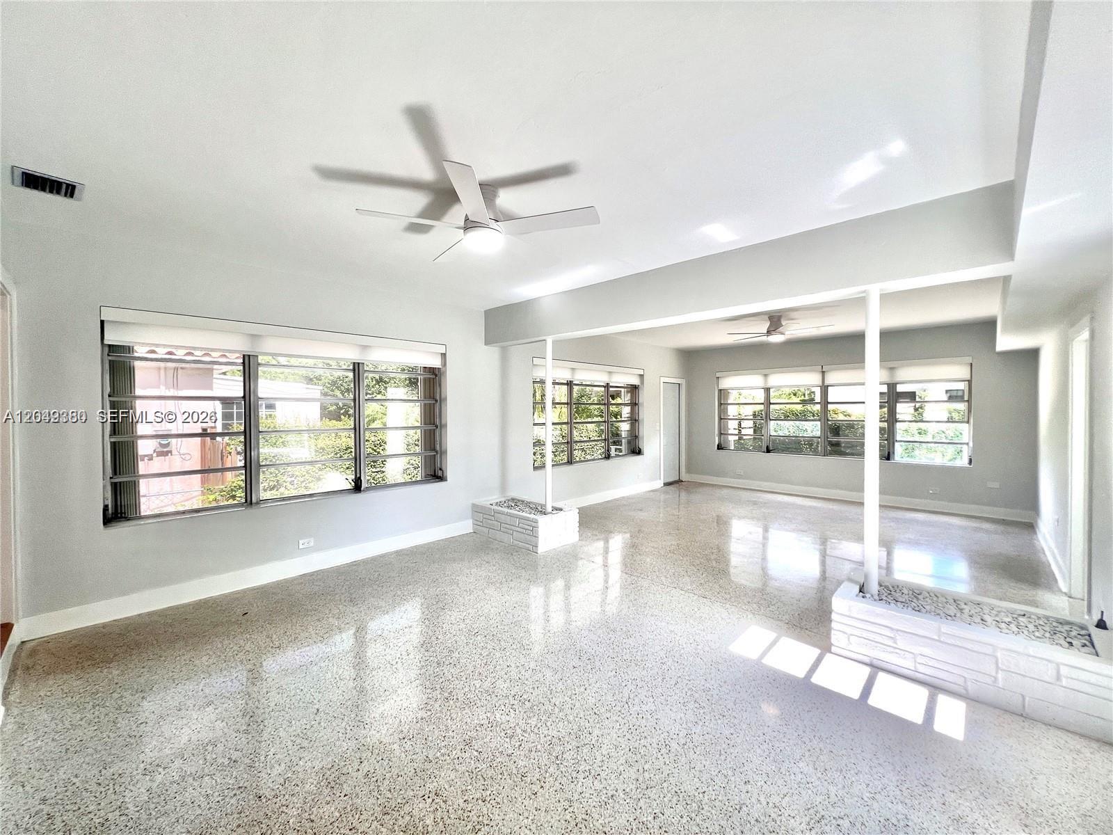 A bright, open-concept living area features polished terrazzo floors, white walls, and two ceiling fans — 2245 SW 25th Ter # 0, Miami FL 33133, MIAMI, FL