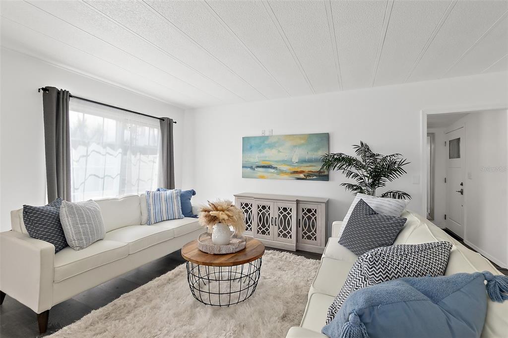 A living room features two white sofas, a round coffee table, and a decorative console — 5660 WOOD STREET, PORT ORANGE, FL