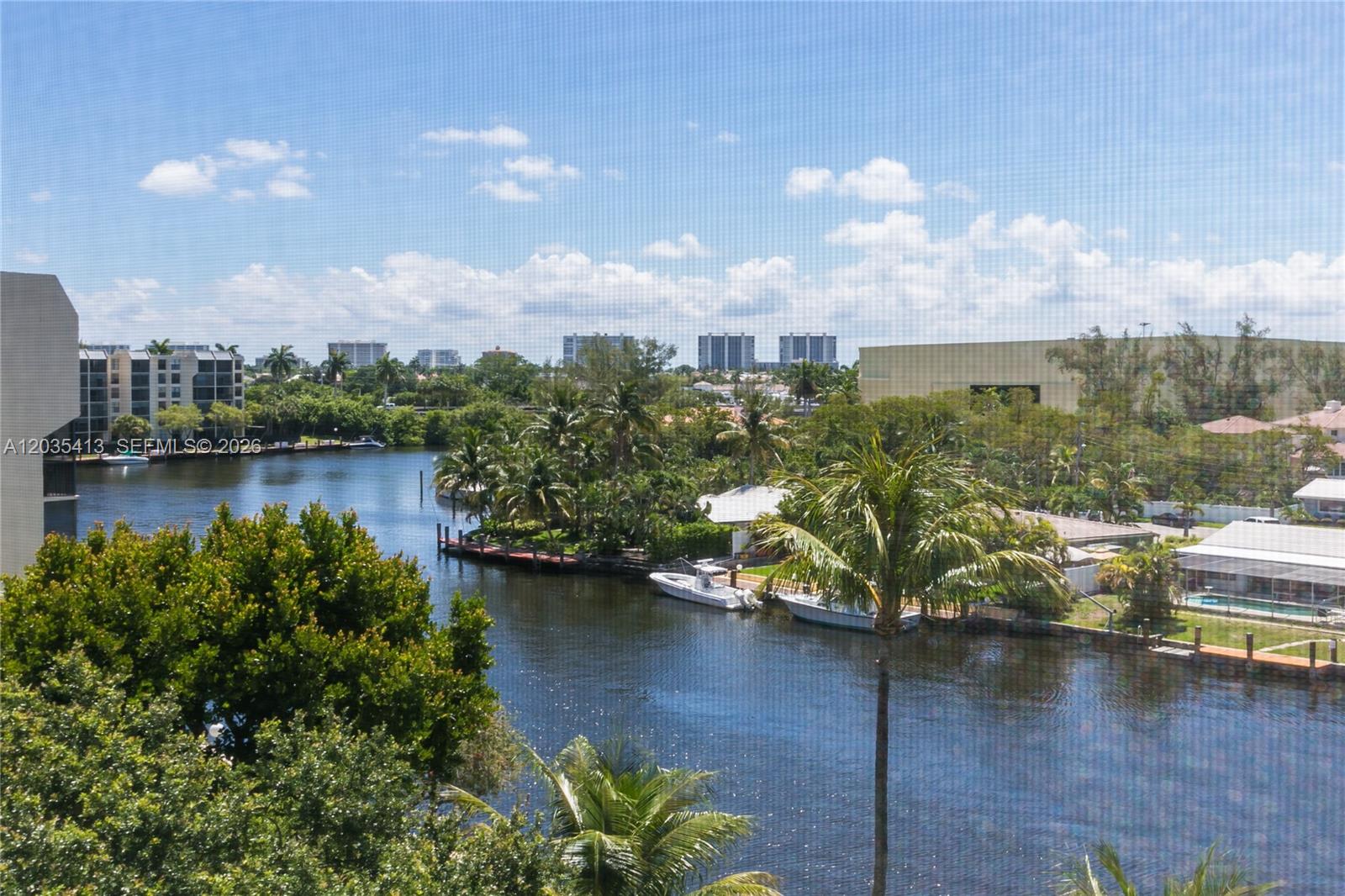 An elevated view shows a canal with boats, palm trees, and distant buildings — 14 Royal Palm Way # 601, Boca Raton FL 33432, BOCA RATON, FL