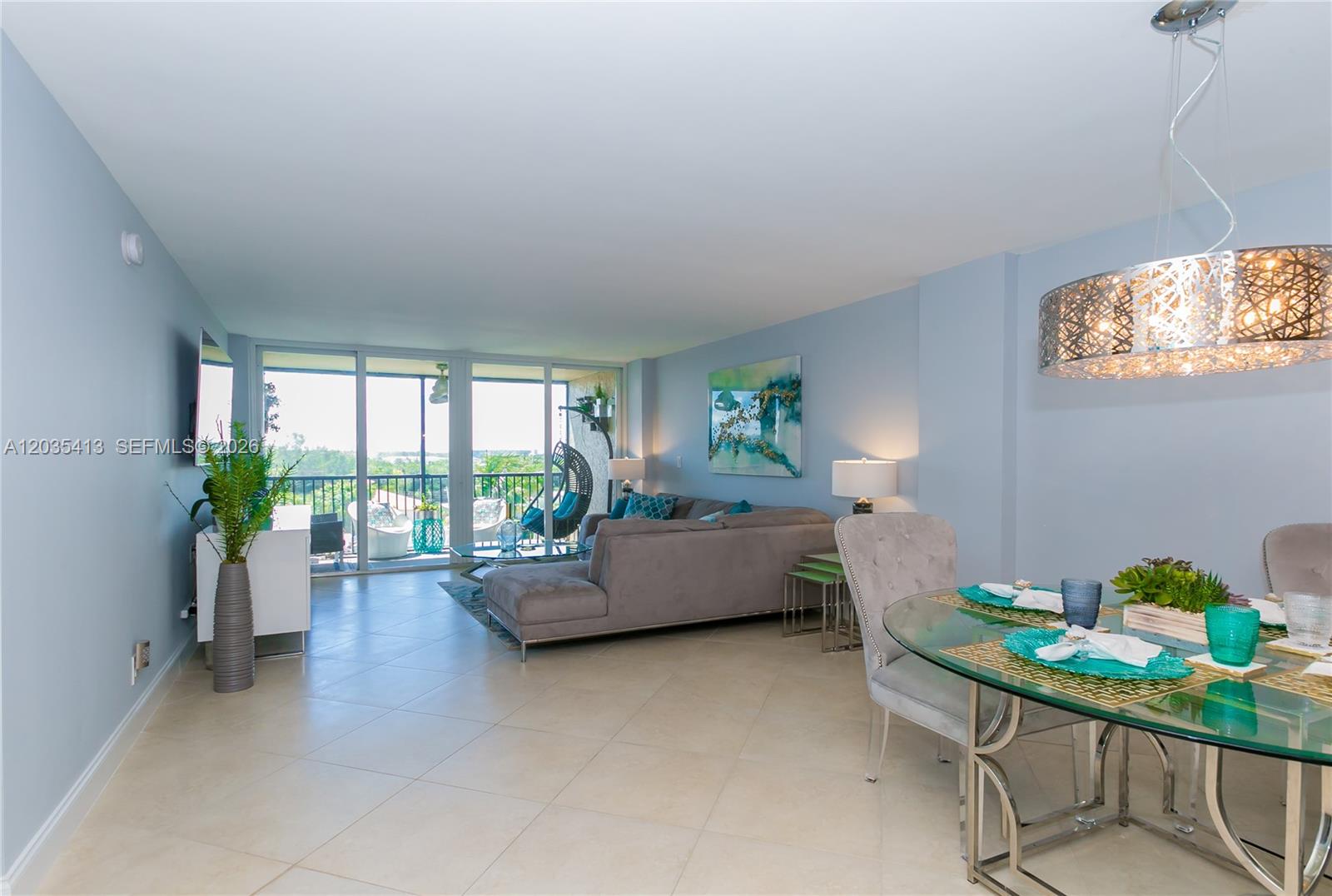 This living and dining area features light blue walls, tile flooring, and a glass-topped table — 14 Royal Palm Way # 601, Boca Raton FL 33432, BOCA RATON, FL