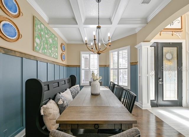 A dining room features a wooden table, a black bench, and blue wainscoting — 10119 DEERCLIFF DR, TAMPA, FL