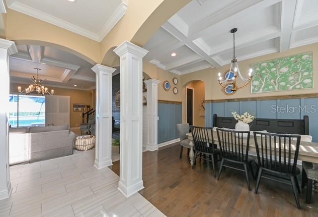 A dining area with wainscoting and a coffered ceiling opens into a living room — 10119 DEERCLIFF DR, TAMPA, FL
