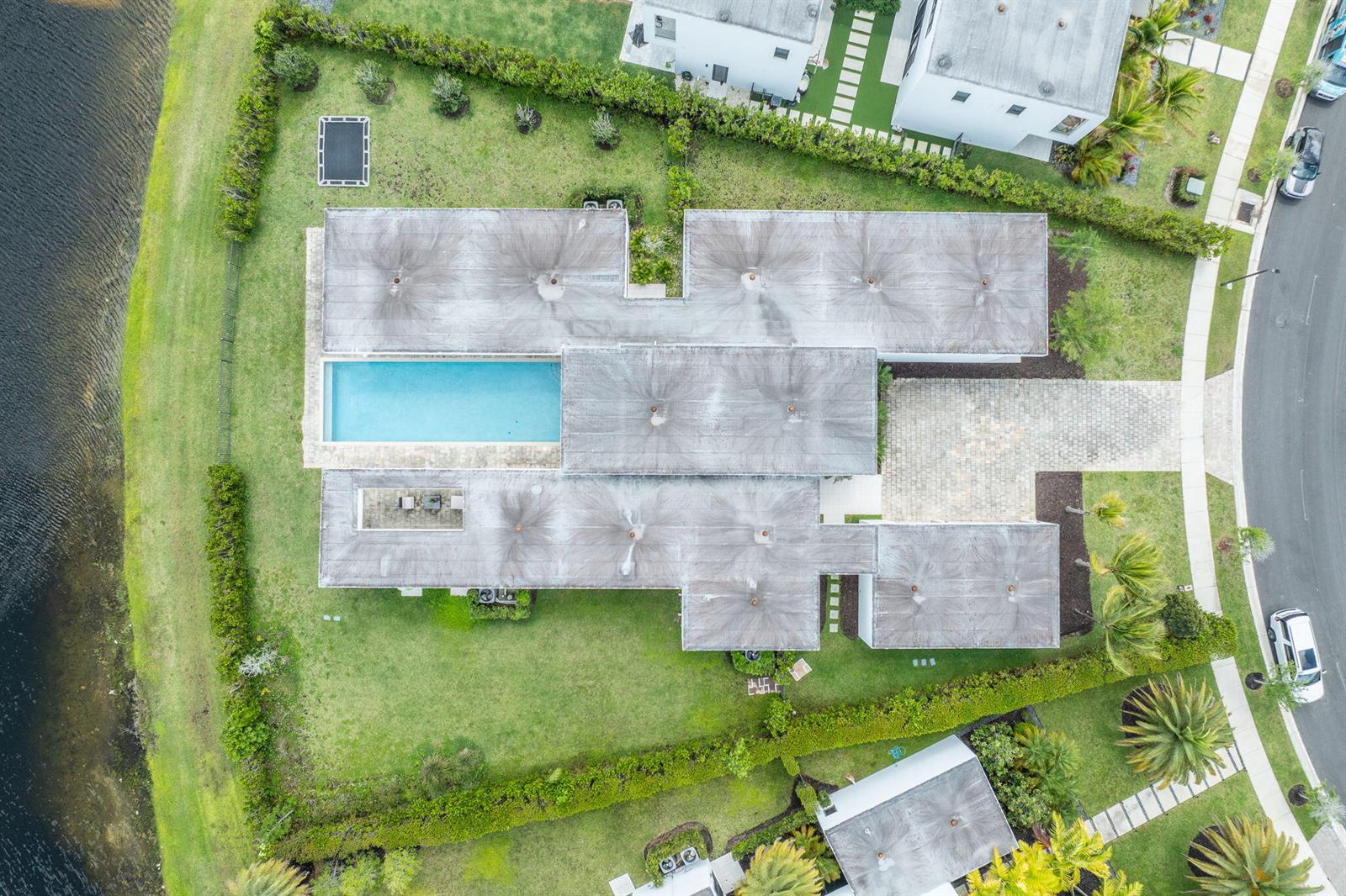 An aerial view shows a modern house with a flat roof, swimming pool, and backyard — 16539 N Botaniko Dr Drive N, Weston FL 33326, WESTON, FL