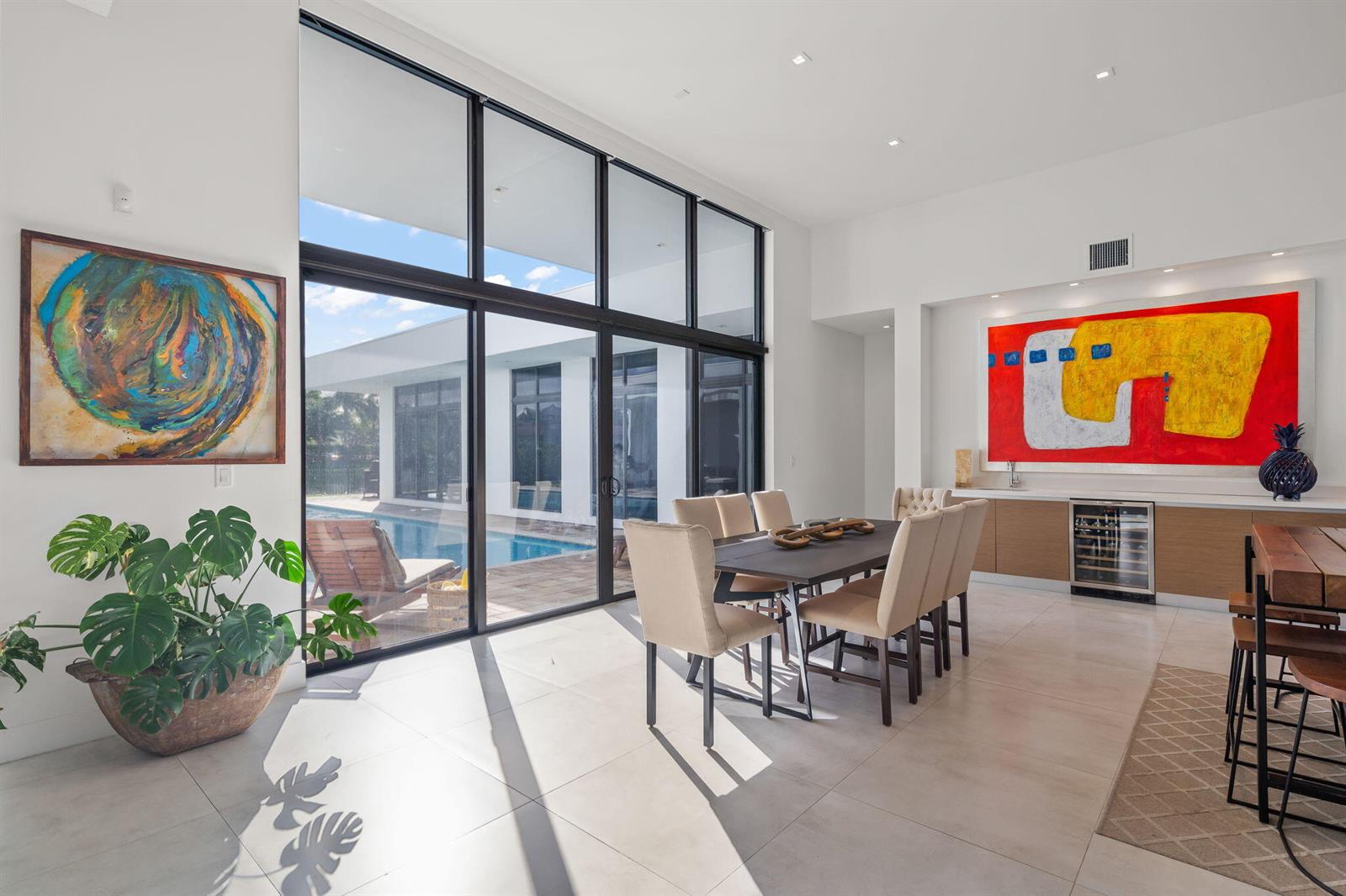 A dining room with a large table, floor-to-ceiling windows, and a view of a pool — 16539 N Botaniko Dr Drive N, Weston FL 33326, WESTON, FL