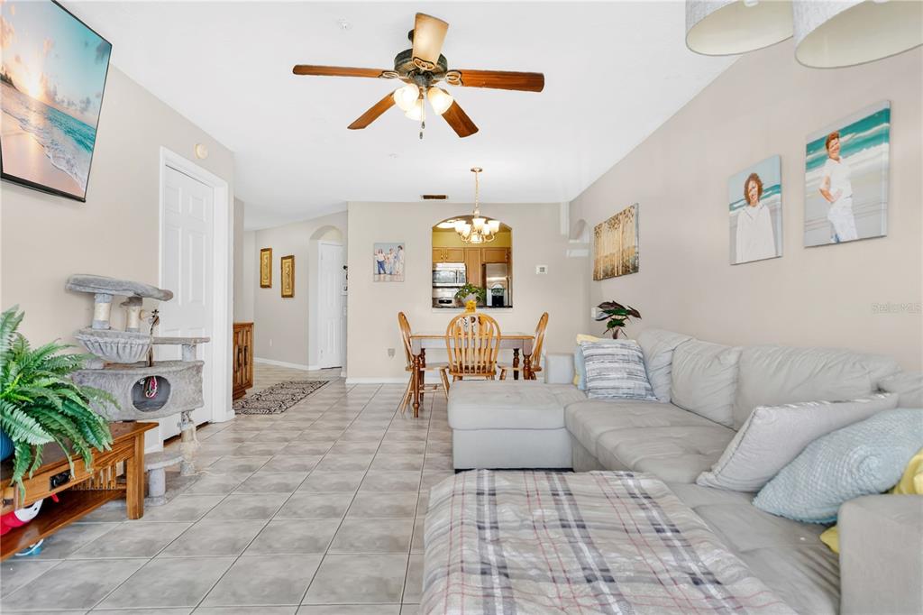 A living room with tile flooring, a sectional sofa, a dining area, and a ceiling fan — 3930 SOUTHPOINTE DRIVE UNIT 214, ORLANDO, FL