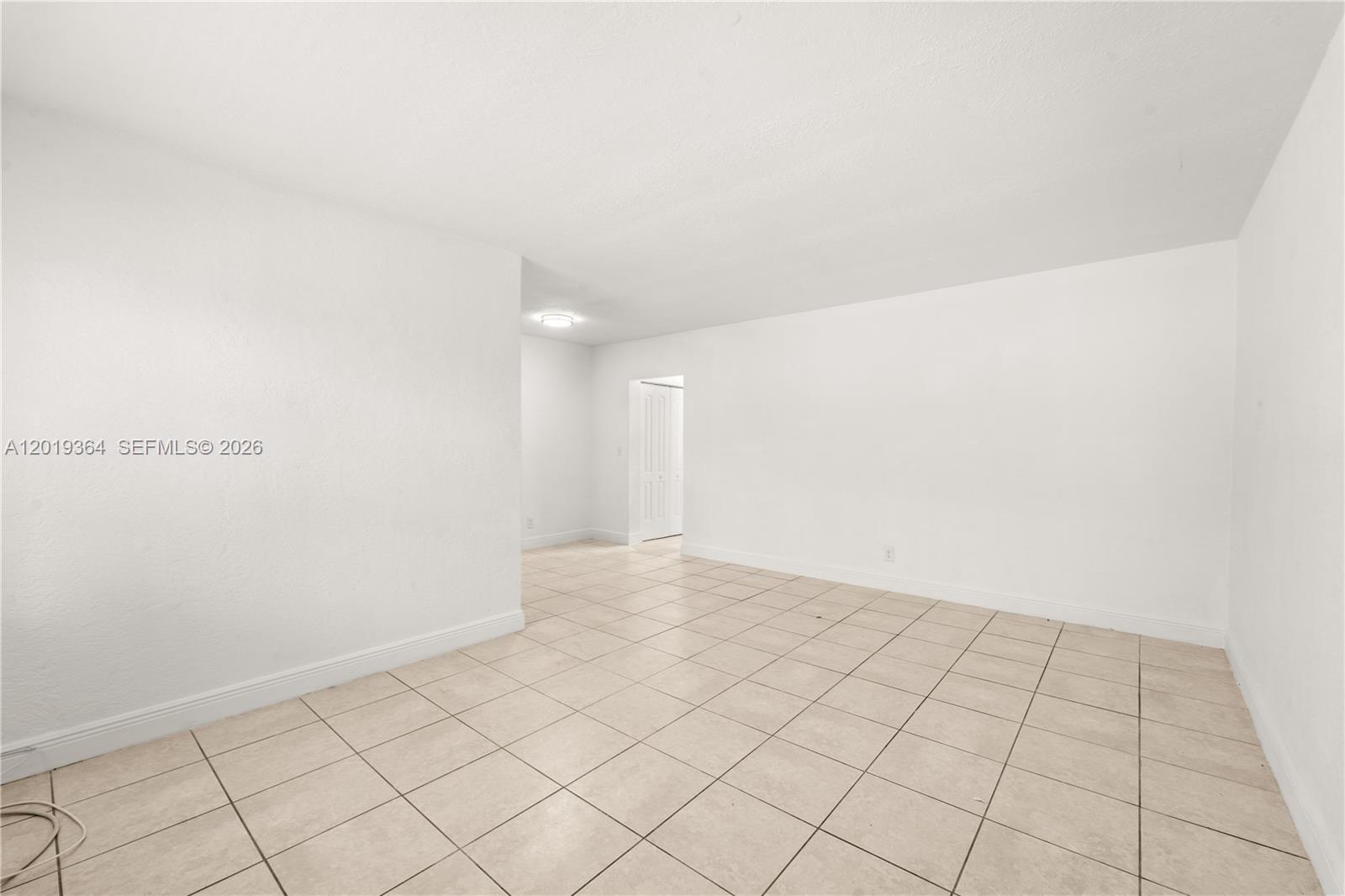 An empty room features white walls, a tiled floor, and a doorway leading to another area — 6905 Rue Vendome # 8, Miami Beach FL 33141, MIAMI BEACH, FL