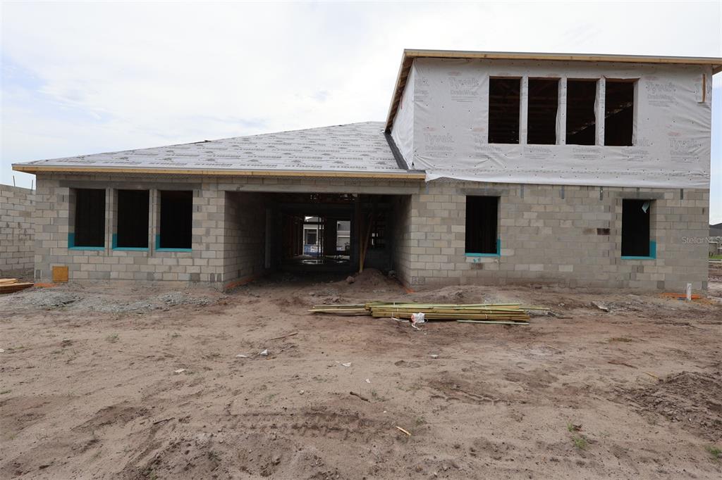 An exterior view of a two-story house under construction with concrete block walls and Tyvek — 2628 RAVENCLIFFE, OVIEDO, FL