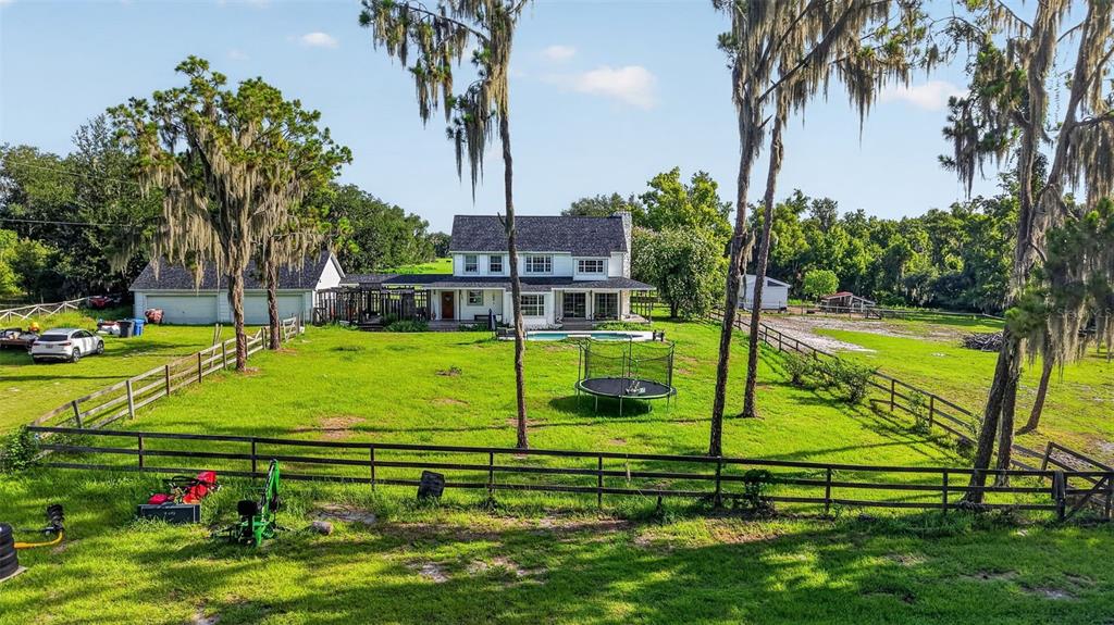 A two-story white house with a pool and trampoline sits on a large grassy lot — 8922 PRITCHER ROAD, LITHIA, FL