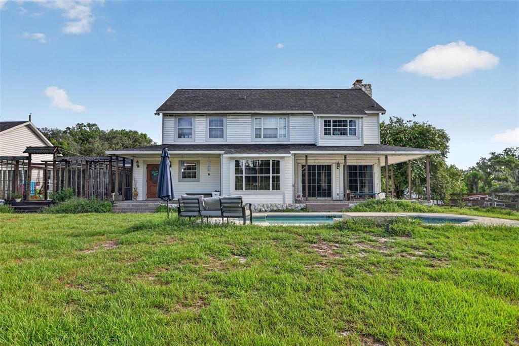A two-story white house with a pool and a covered porch in the backyard — 8922 PRITCHER ROAD, LITHIA, FL