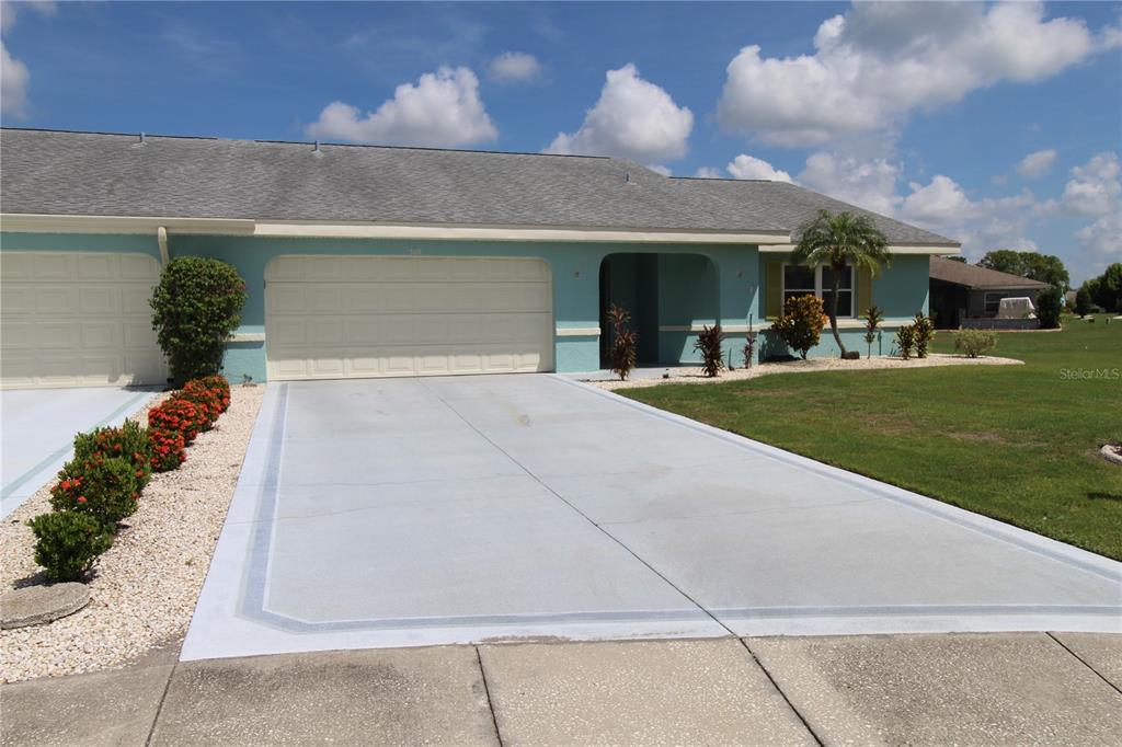 A light blue single-story duplex with a two-car garage and a concrete driveway — 309 BRYCE COURT, SUN CITY CENTER, FL