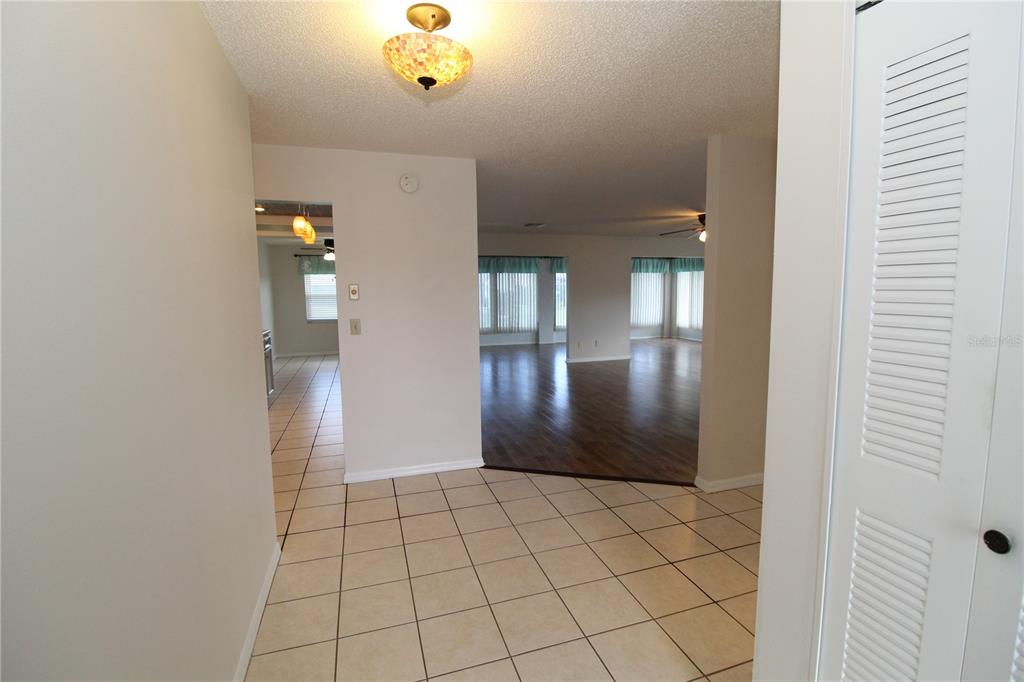 A tiled entryway leads to a living area with wood-look flooring and large windows — 309 BRYCE COURT, SUN CITY CENTER, FL