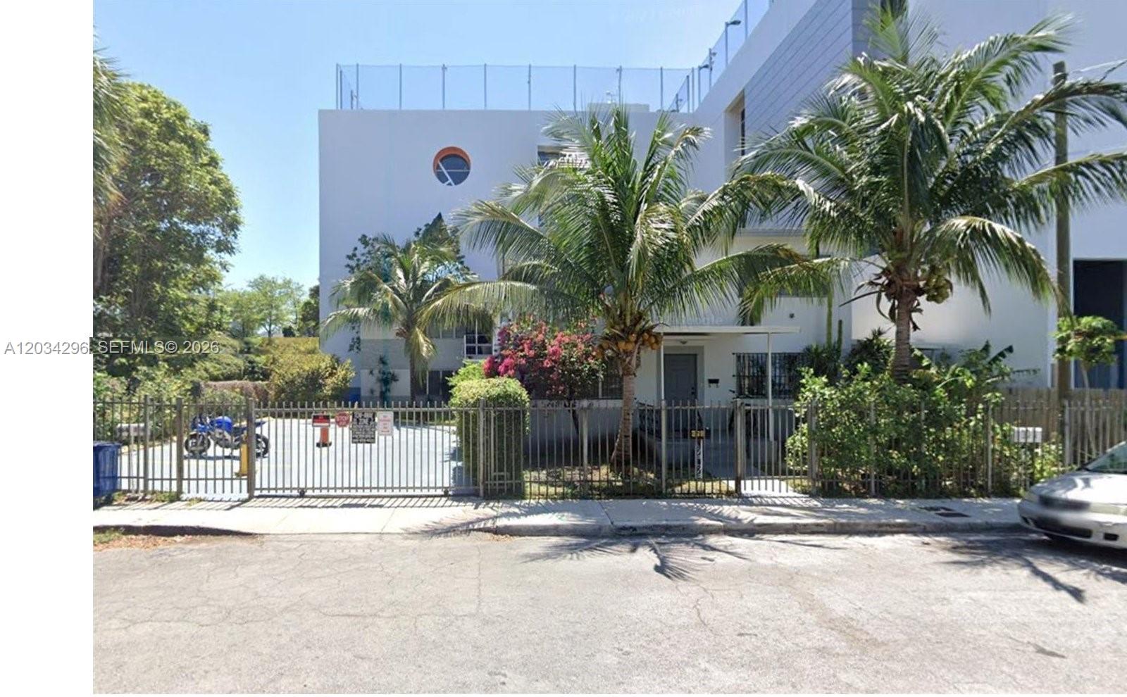 A white multi-story building features a gated parking area and palm trees in front — 364 SW 11th St, Miami FL 33130, MIAMI, FL