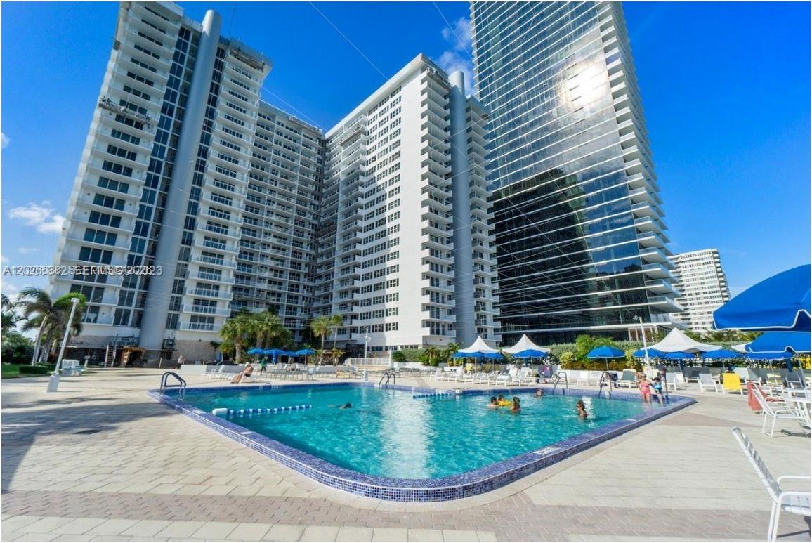 A swimming pool sits in front of two large, modern residential high-rise buildings — 2030 S Ocean Dr # 723, Hallandale Beach FL 33009, HALLANDALE BEACH, FL