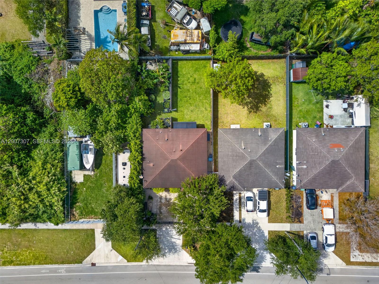 An aerial view shows three residential houses with driveways, backyards, and surrounding trees — 12310 SW 216th St, Miami FL 33170, MIAMI, FL