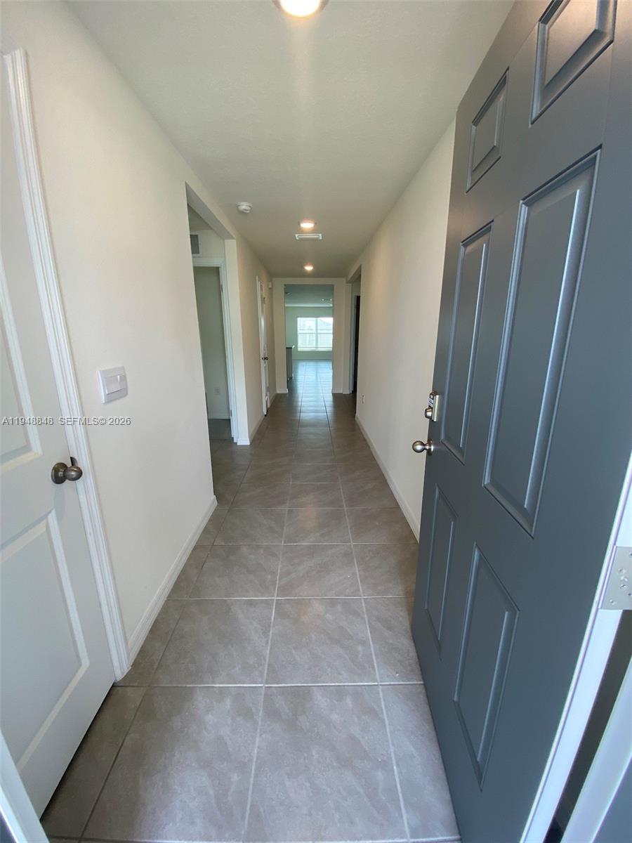 A tiled hallway leads from an open gray front door toward a distant window — 8864 SW 49th CIRCLE, Ocala FL 34476, OCALA, FL