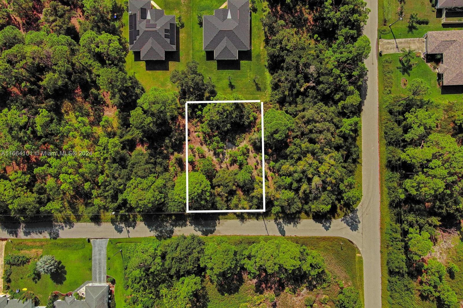 An aerial view shows a rectangular vacant lot outlined in white amidst a wooded area — #1 Ginsa Ter, North Port FL 34291, NORTH PORT, FL