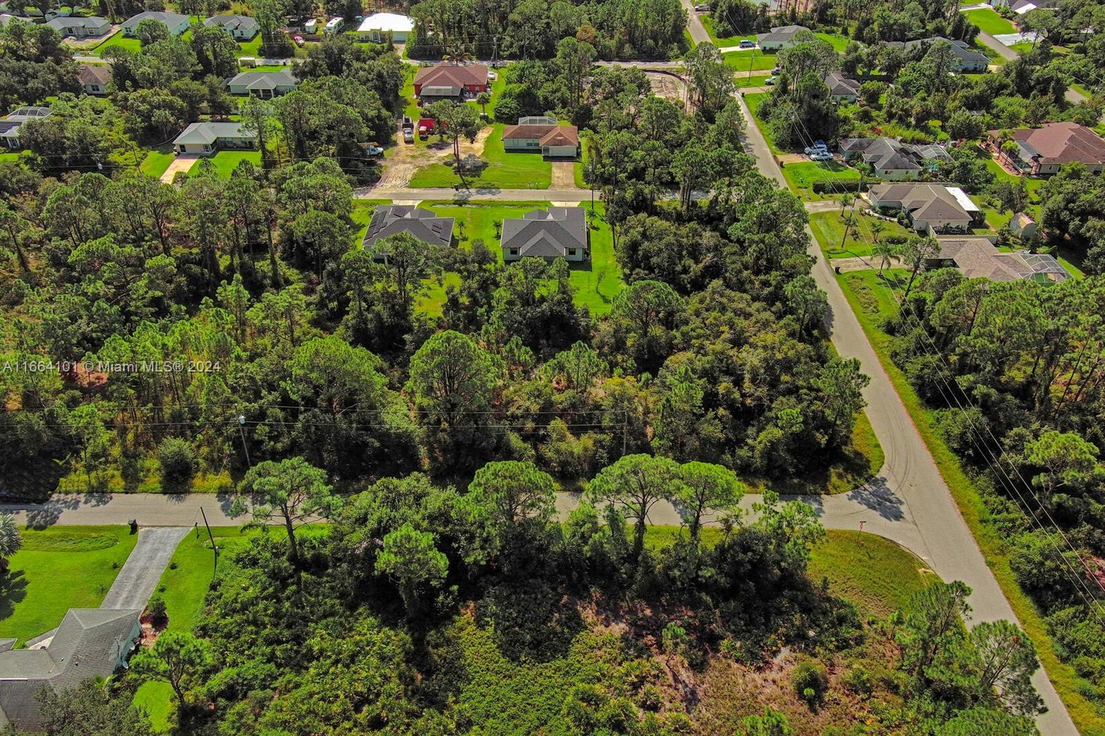 An aerial view shows several houses surrounded by dense trees and paved residential streets — #1 Ginsa Ter, North Port FL 34291, NORTH PORT, FL