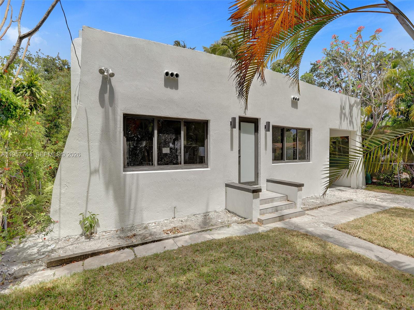 A single-story white stucco house features a front entrance with steps and a flat roof — 759 NE 127th St, North Miami FL 33161, NORTH MIAMI, FL