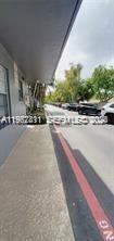A concrete sidewalk runs alongside a building exterior with a red curb and parked cars — 4853 NW 9th Dr # 4853, Plantation FL 33317, PLANTATION, FL
