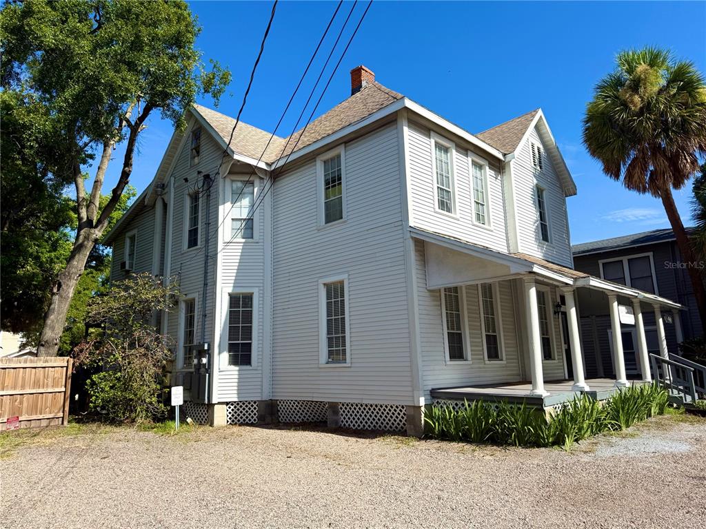 A two-story white house with a covered front porch and lattice skirting — 311 S BREVARD AVENUE, TAMPA, FL