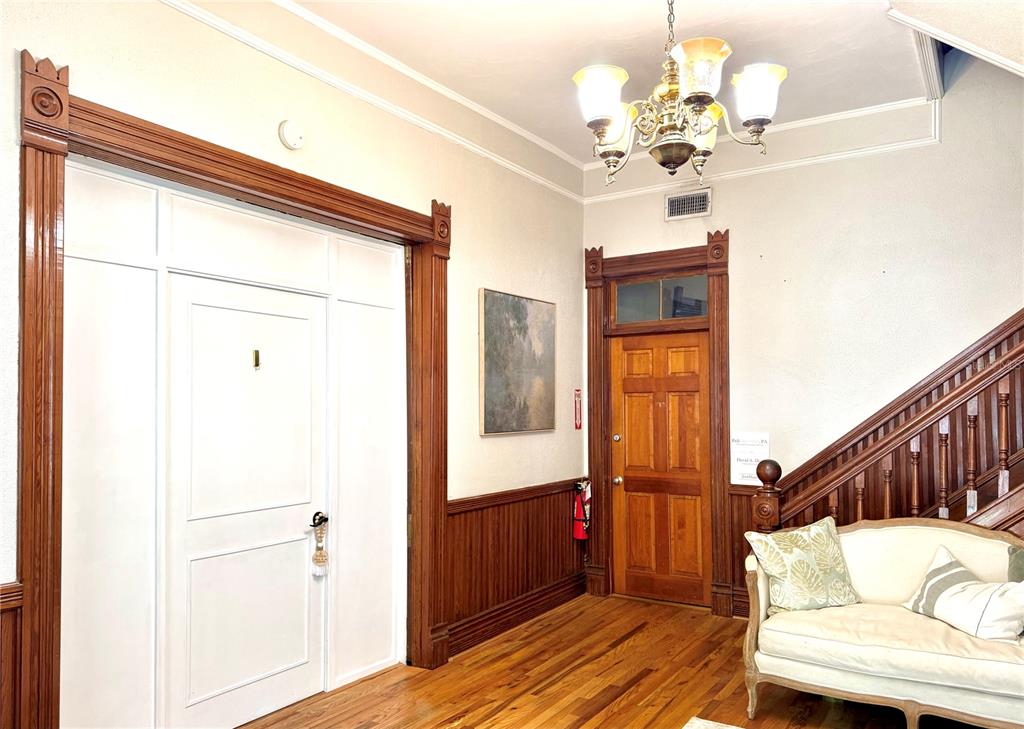 An interior entryway features wood trim, a white door, a staircase, and a chandelier — 311 S BREVARD AVENUE, TAMPA, FL