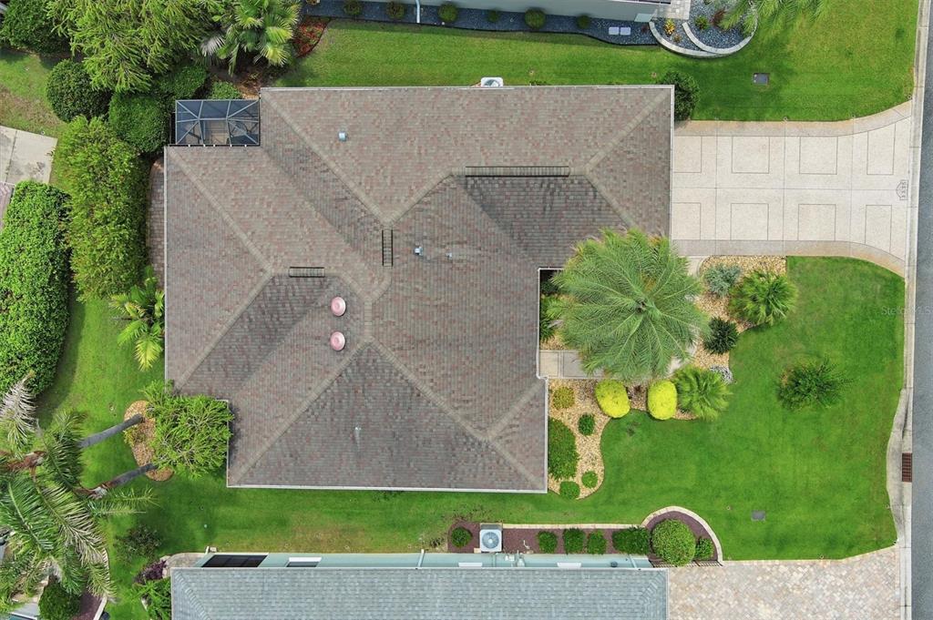 An aerial view shows a residential house with a shingled roof, driveway, and landscaped yard — 3335 DALKEITH TERRACE, THE VILLAGES, FL