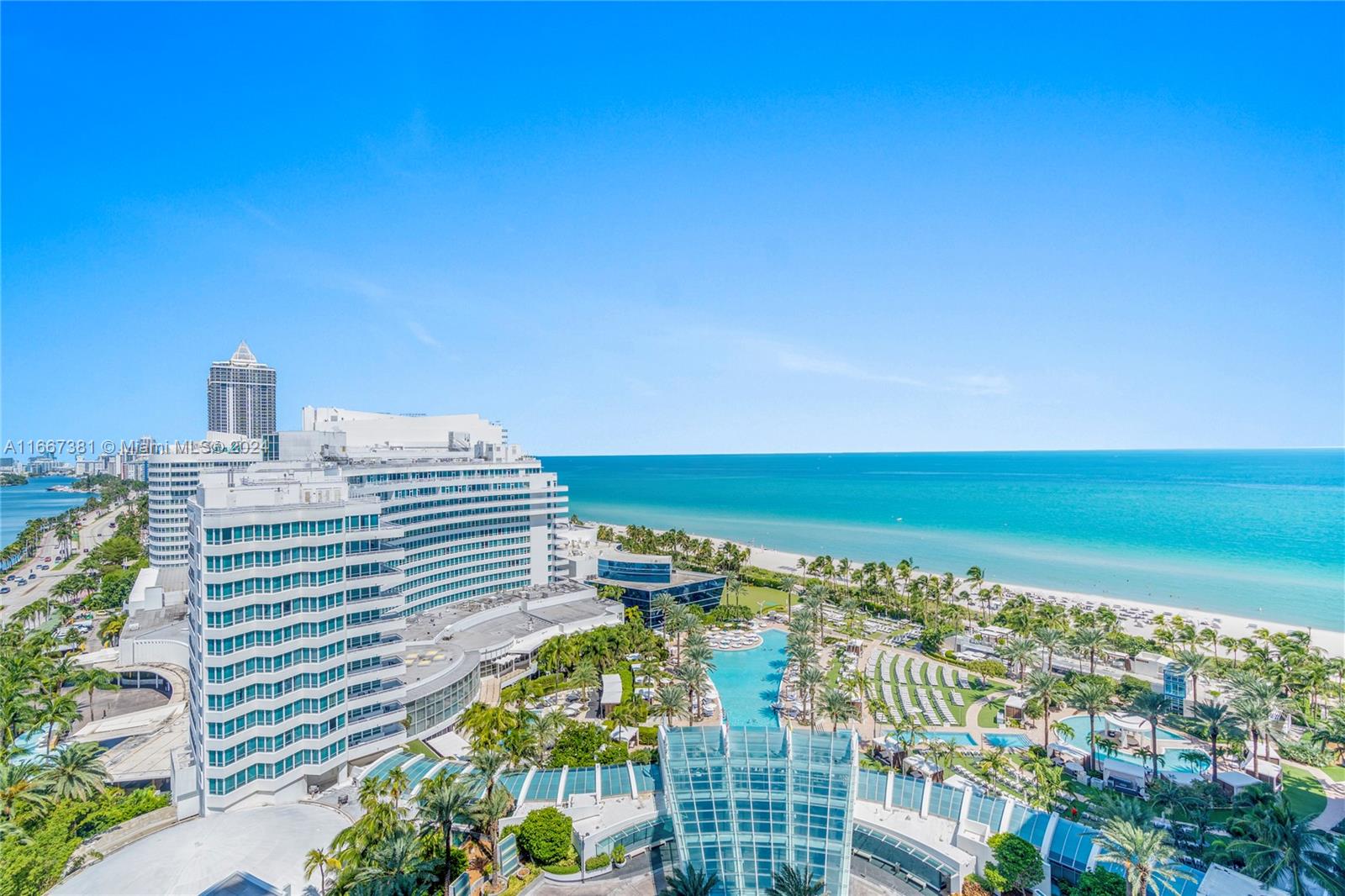 An aerial view shows a large hotel complex with pools and palm trees by the ocean — 4401 Collins Ave # 1709, Miami Beach FL 33140, MIAMI BEACH, FL