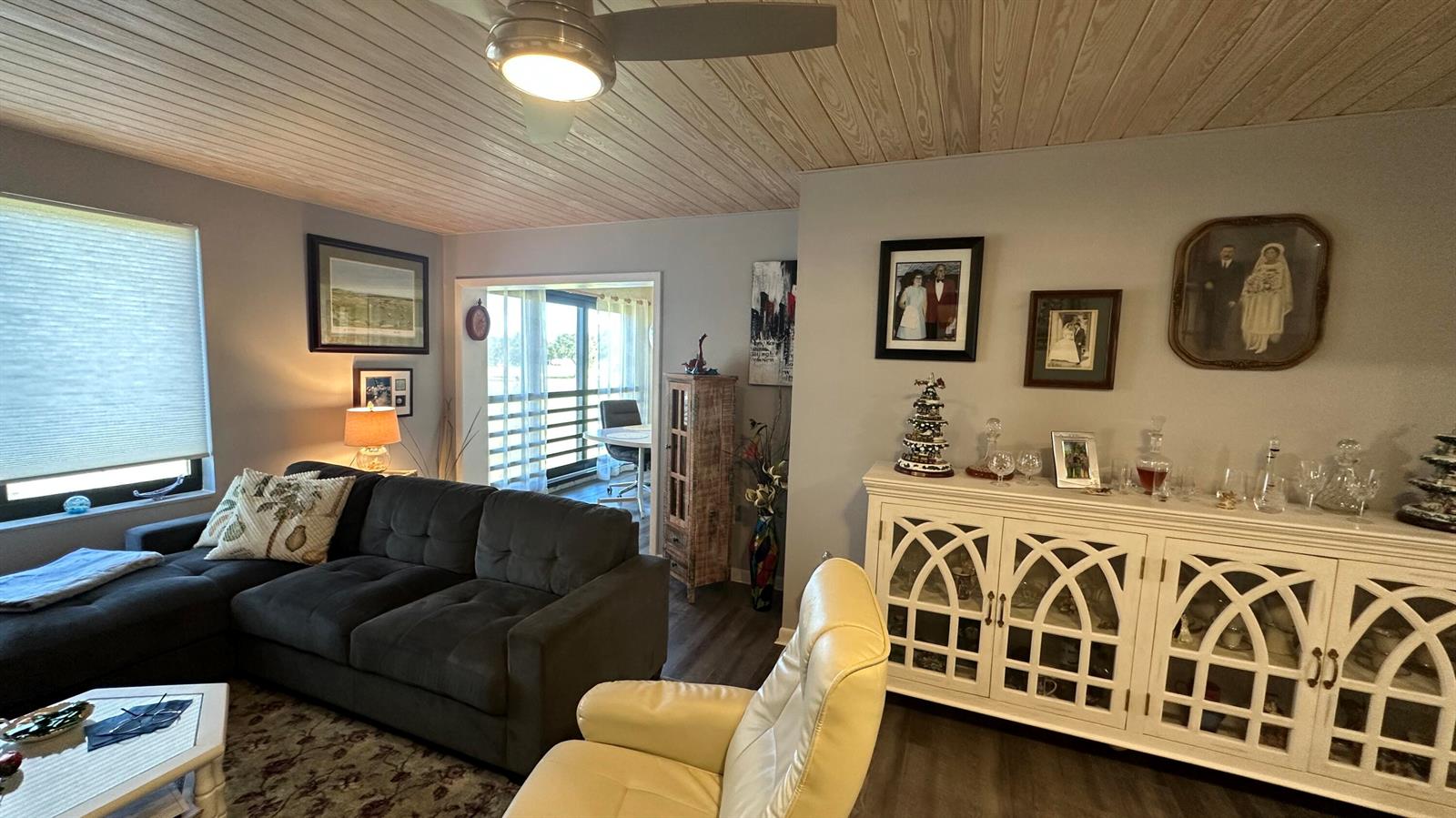 A living room features a dark sectional sofa, a white cabinet, and a ceiling fan — 5355 SE Miles Grant Road # 209, Stuart FL 34997, STUART, FL