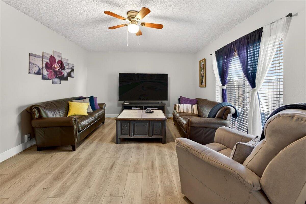 A living room features two brown leather sofas, a coffee table, and wood-look flooring — 6351 Seven Springs Boulevard # B, FL 33463, FL