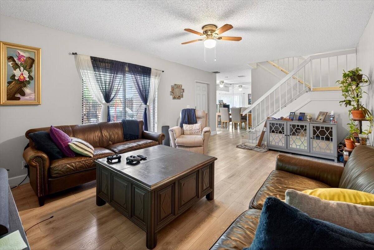 A living room features two leather sofas, a coffee table, and a staircase — 6351 Seven Springs Boulevard # B, FL 33463, FL