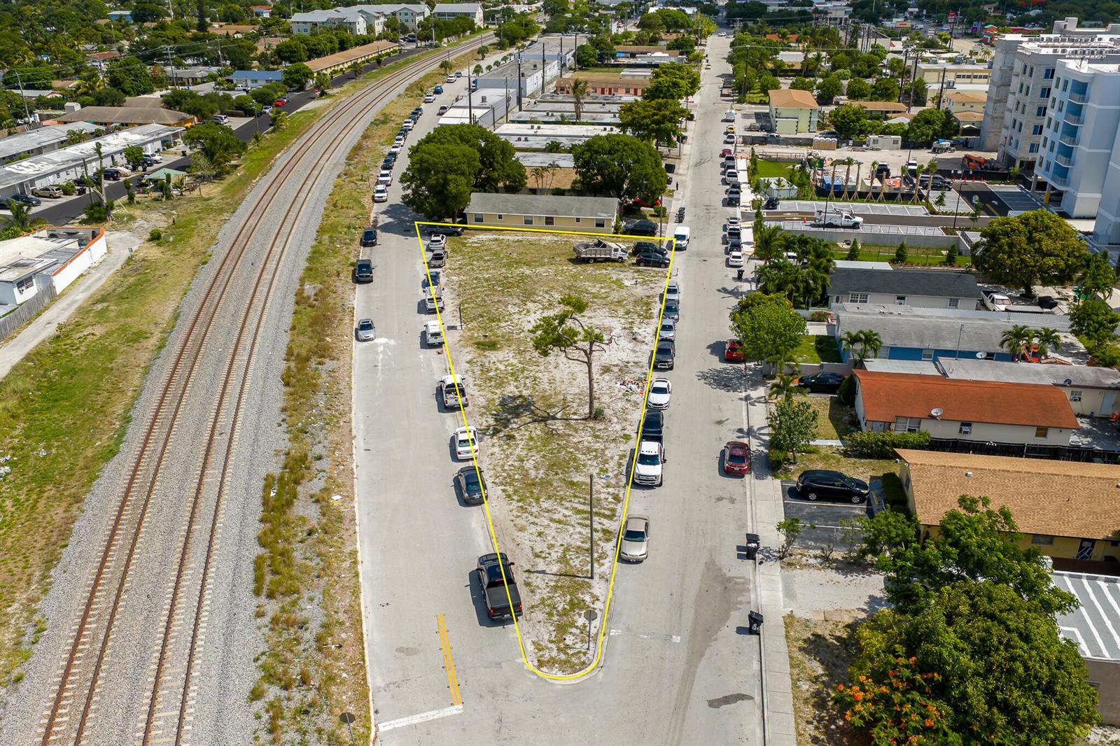 An aerial view shows a triangular vacant lot bordered by streets and railroad tracks — 901 S H Street, FL 33460, FL