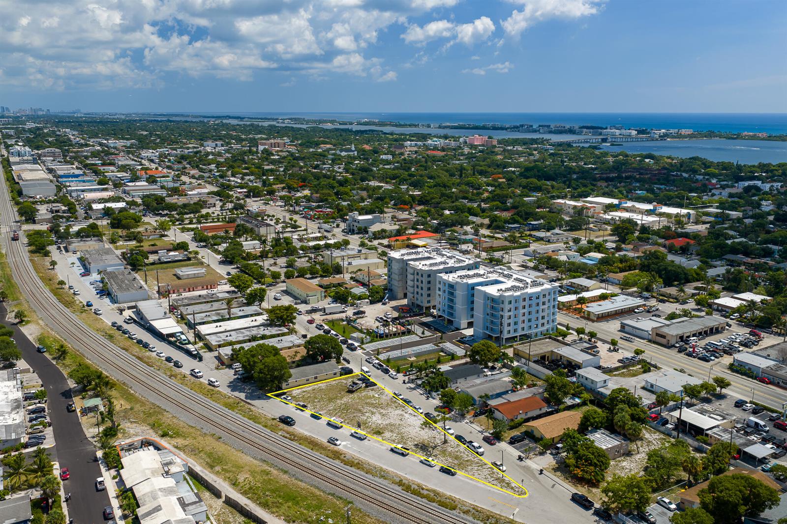 An aerial view shows a vacant, triangular-shaped lot adjacent to railroad tracks in a city — 901 S H Street, FL 33460, FL