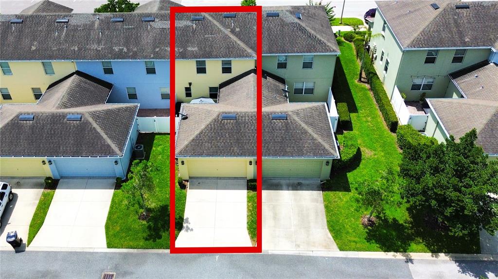 An aerial view shows a yellow townhouse unit with a driveway and a shingled roof — 1217 SEBURN ROAD, APOPKA, FL