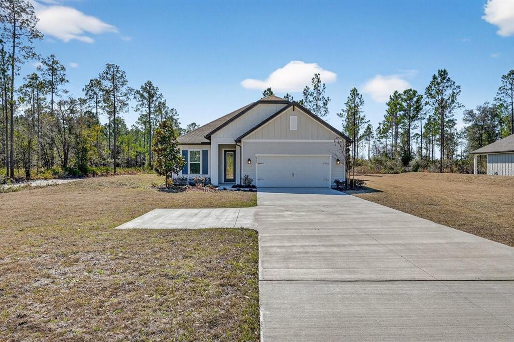 A single-story house with a two-car garage and a concrete driveway sits on a lot — 8719 FORD ROAD, BRYCEVILLE, FL