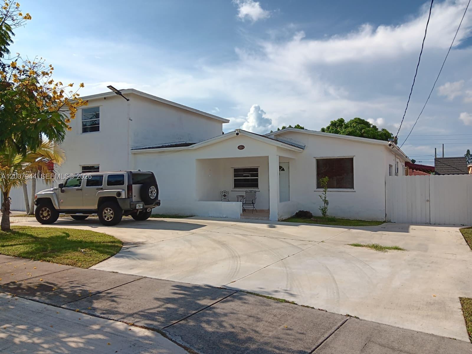 A two-story white house with a concrete driveway and a silver SUV parked outside — 12215 SW 217th St, Miami FL 33170, MIAMI, FL