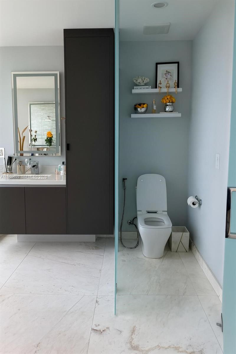 A modern bathroom features a floating vanity, dark cabinetry, and a separate toilet area — 851 NE 1st Ave # 2212, Miami FL 33132, MIAMI, FL