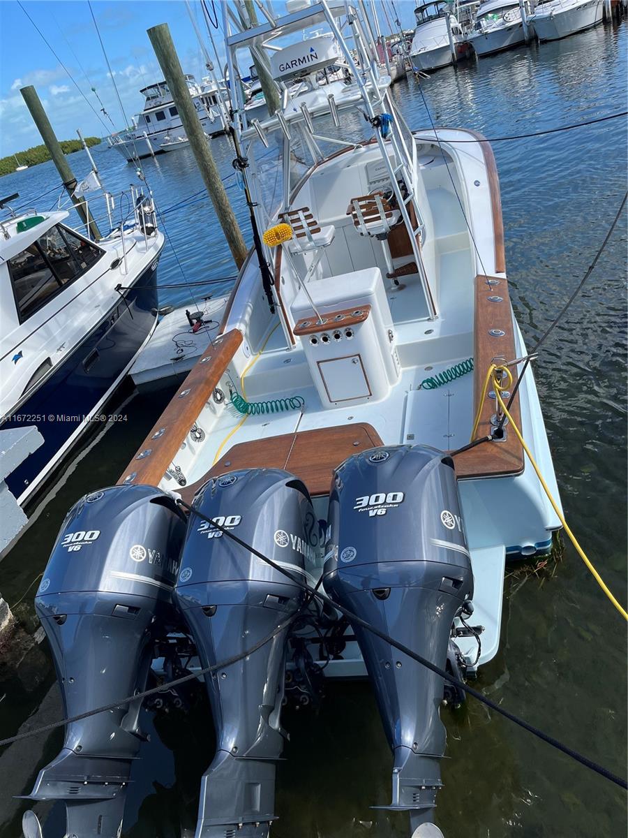 A boat with three Yamaha 300 outboard motors is docked at a marina — 101425 Overseas Highway, Key Largo FL 33037, KEY LARGO, FL