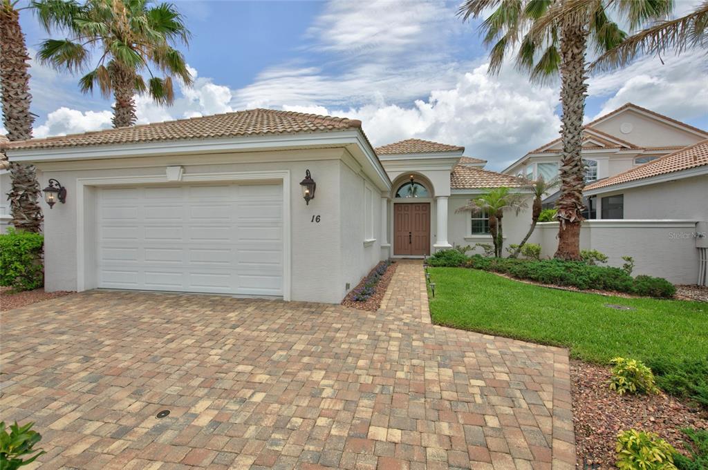 A single-story house with a paved driveway, a two-car garage, and a front entryway — 16 MONTILLA PLACE, PALM COAST, FL
