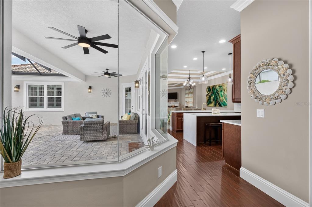 A view from an interior hallway looking through a corner window into a covered patio — 16 MONTILLA PLACE, PALM COAST, FL