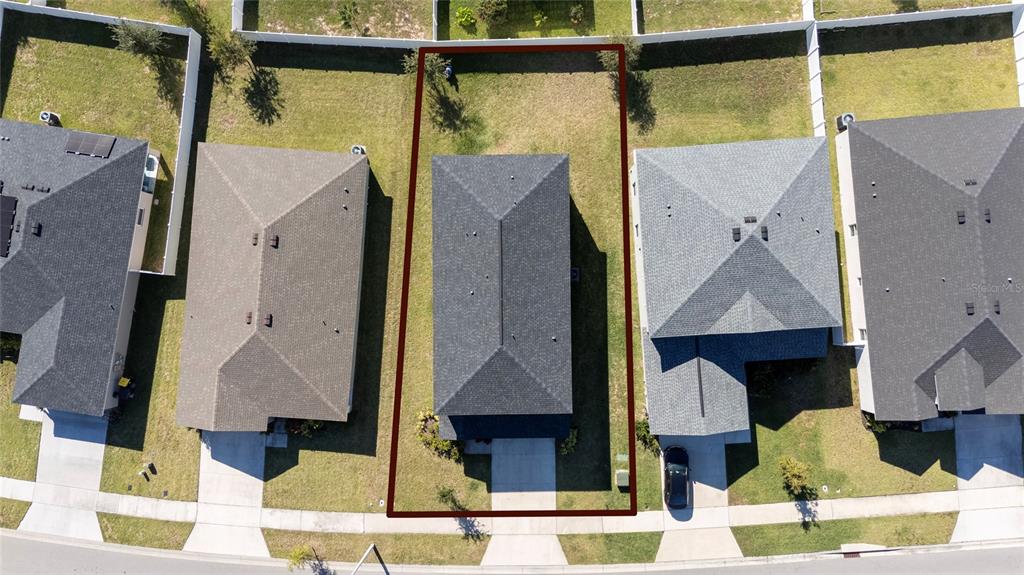 An aerial view shows a single-family home centered on a rectangular lot with a backyard — 419 LILY LANE, DAVENPORT, FL